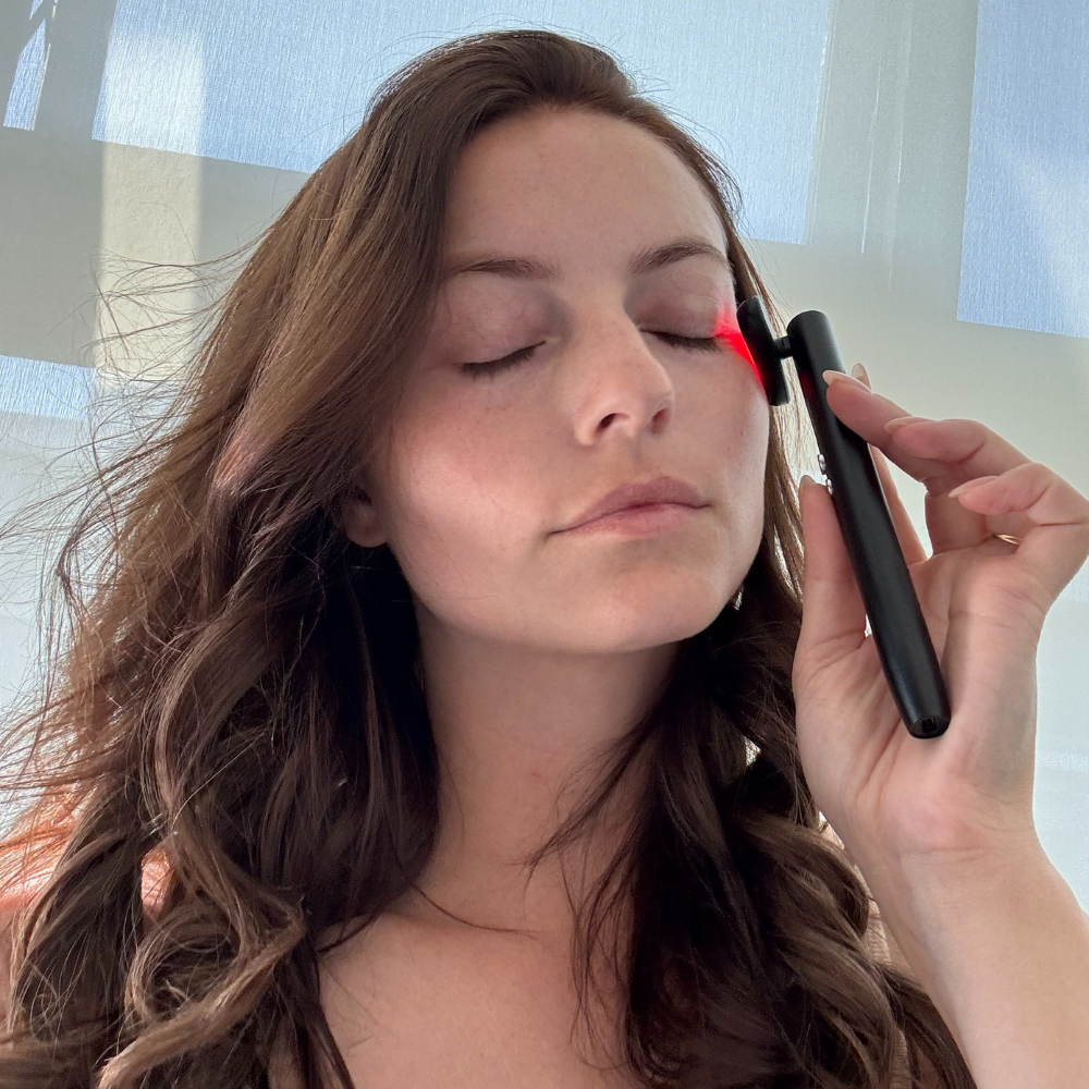 Handheld Red Light wand for firming and brightening in use on cheek area